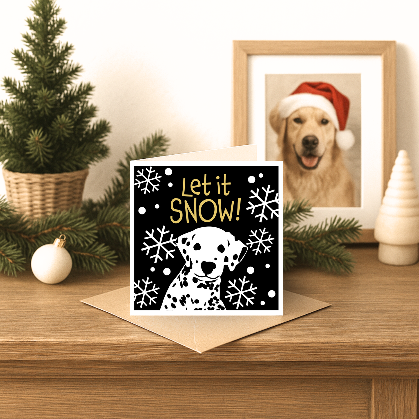 Christmas card with 'Let it Snow!' text and a dog illustration on a wooden surface with festive decorations.