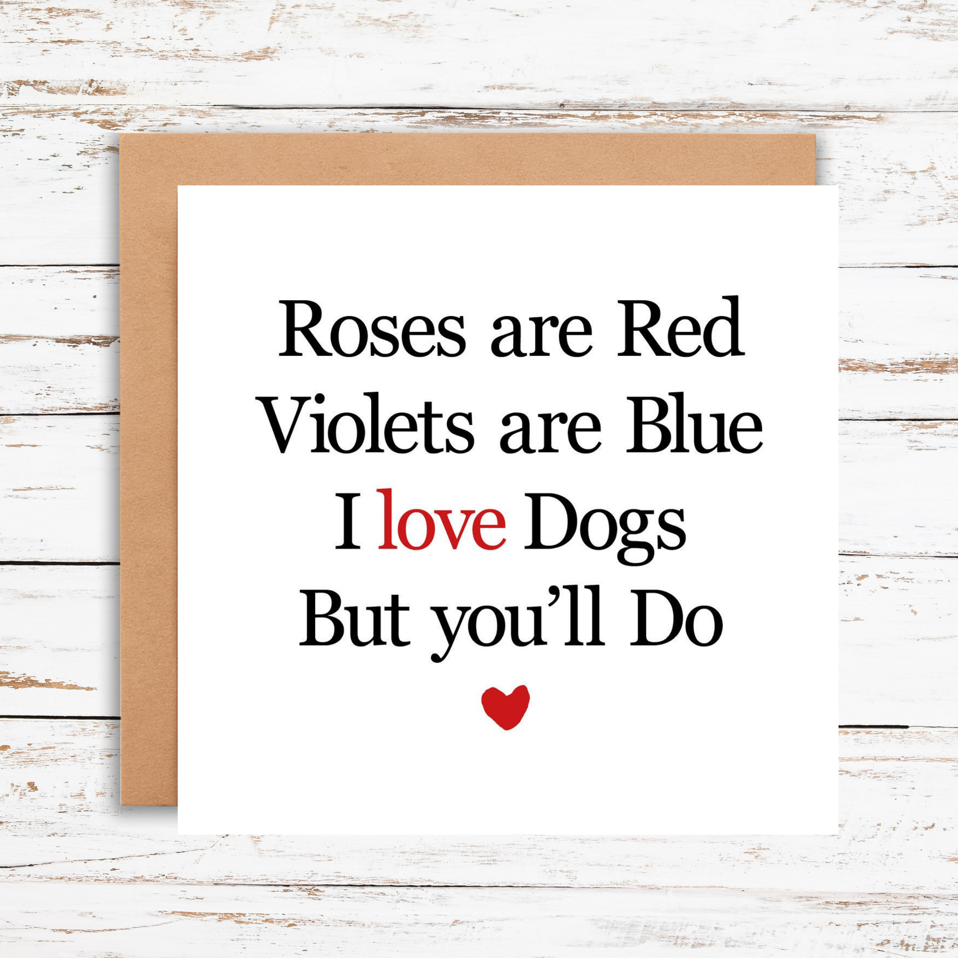 Card with humorous Valentine's Day message about dogs on a wooden surface