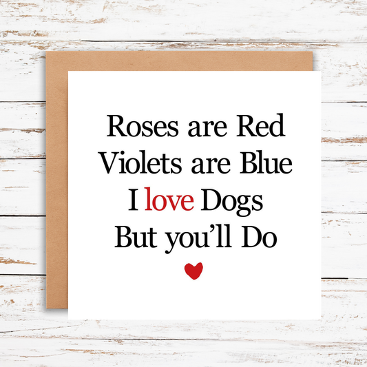 Card with humorous Valentine's Day message about dogs on a wooden surface