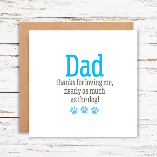 Card with text 'Dad thanks for loving me, nearly as much as the dog!' on a wooden surface