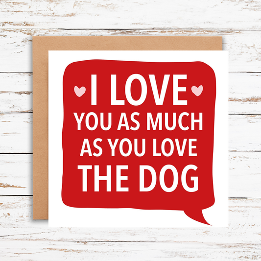 Card with red speech bubble saying 'I love you as much as you love the dog' on a wooden background