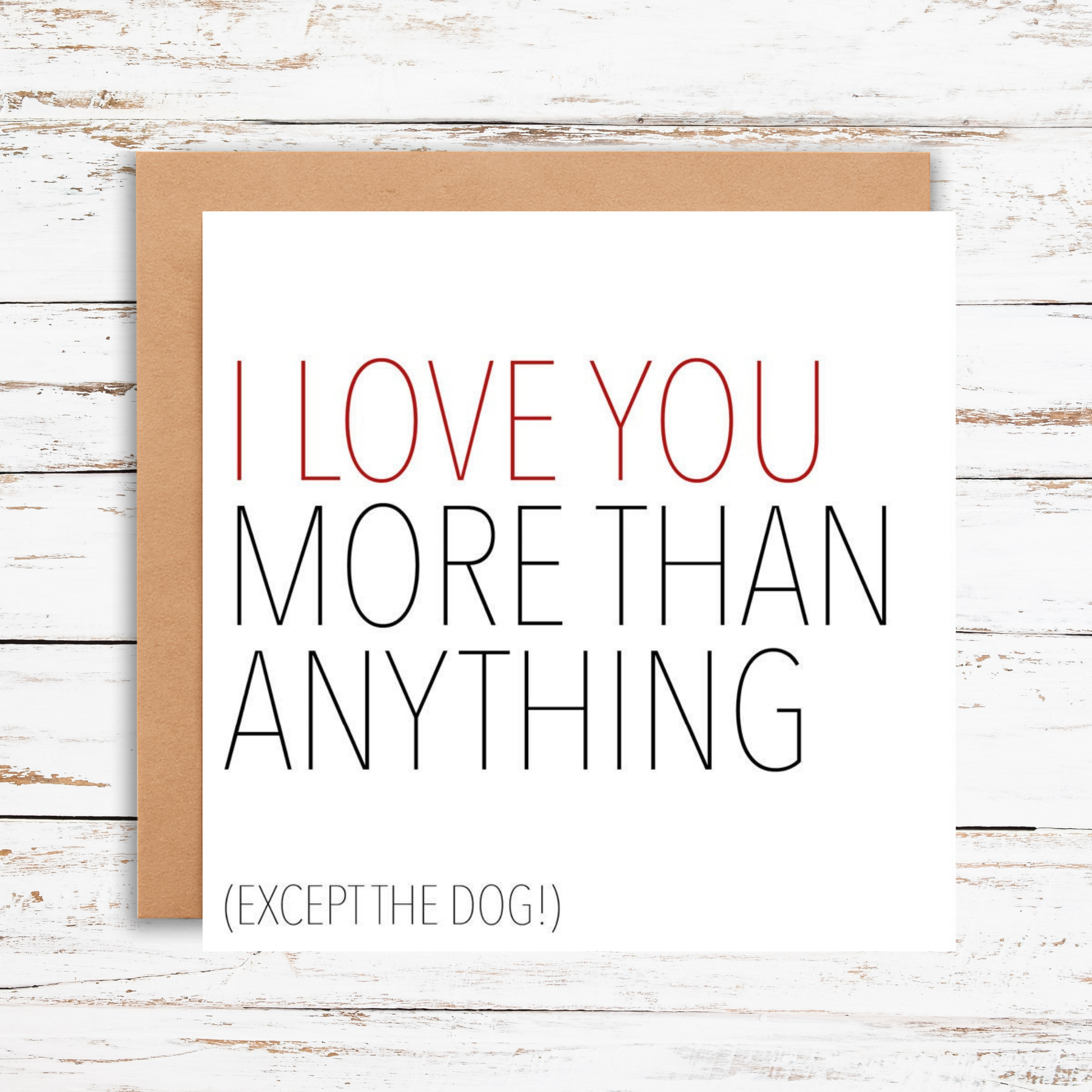 Card with text 'I love you more than anything (except the dog!)' on a wooden surface