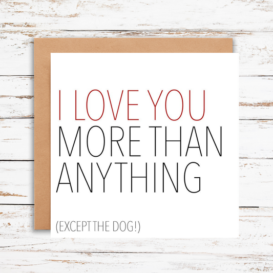 Card with text 'I love you more than anything (except the dog!)' on a wooden surface