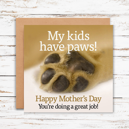 Mother's Day card with a paw print and text on a wooden surface