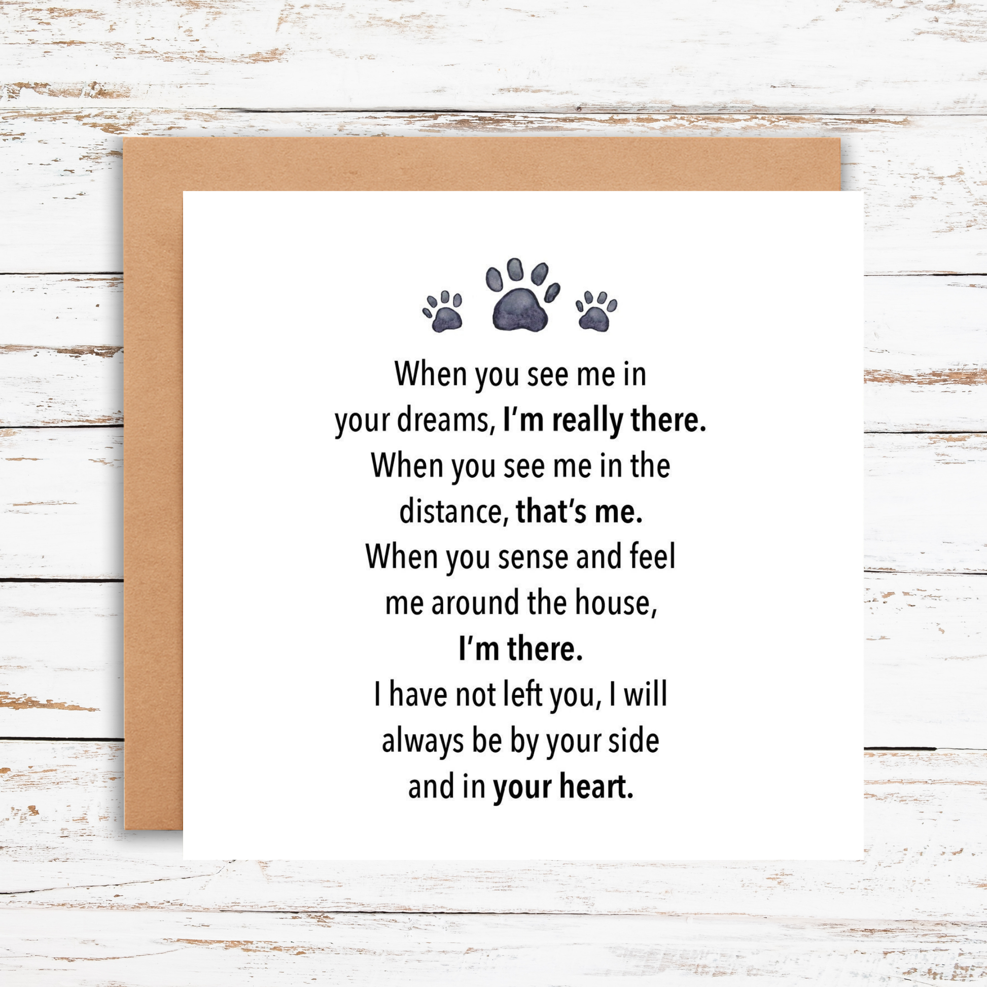 Greeting card with paw prints and text on a wooden surface
