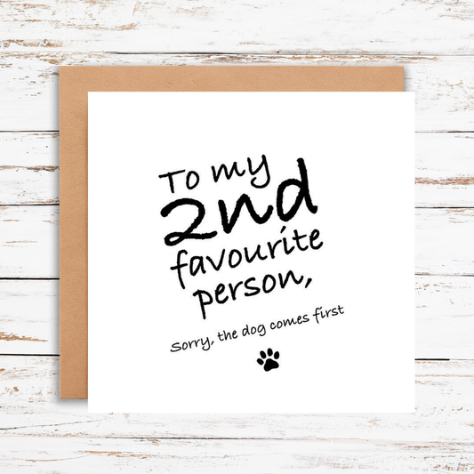 Card with text 'To my 2nd favourite person, sorry the dog comes first' on a wooden surface