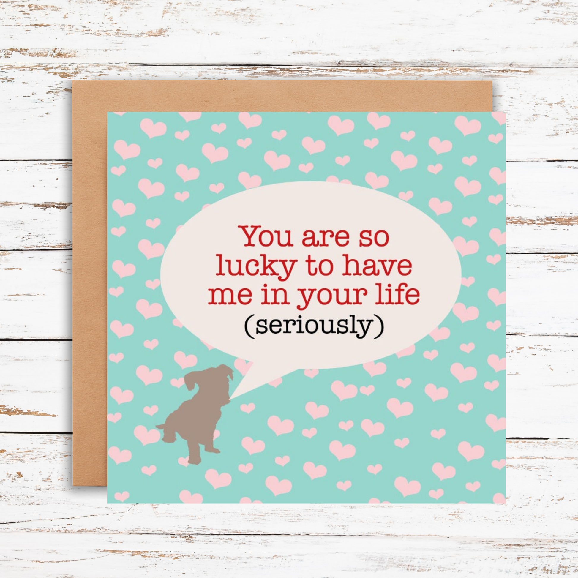 Card with a dog illustration and heart pattern on a wooden surface