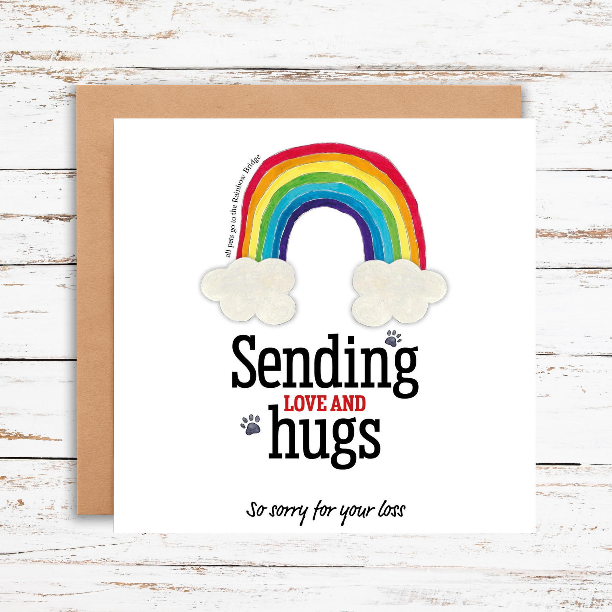 Card with rainbow and clouds design on a wooden surface