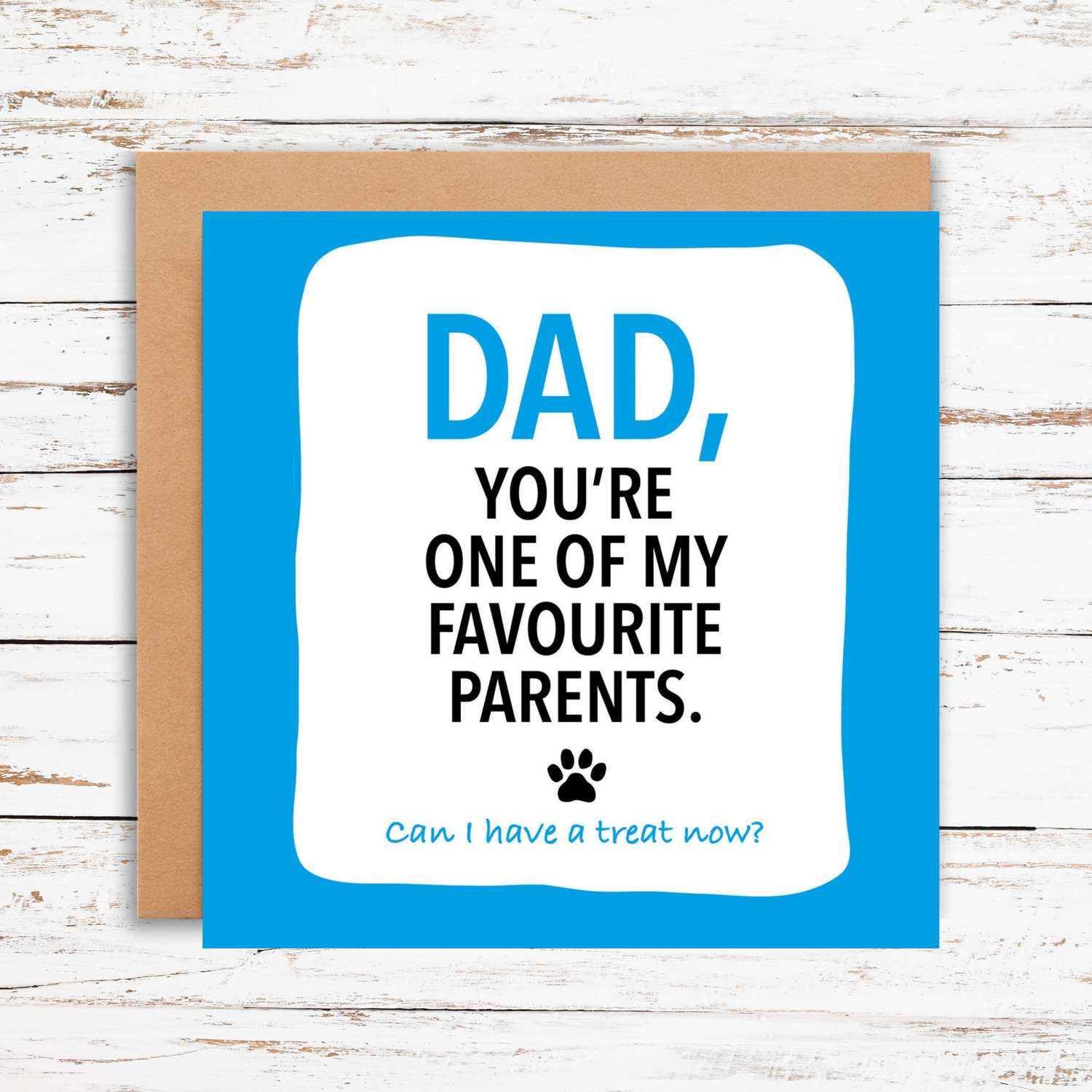 Card with text 'Dad, you're one of my favourite parents. Can I have a treat now?' on a wooden background