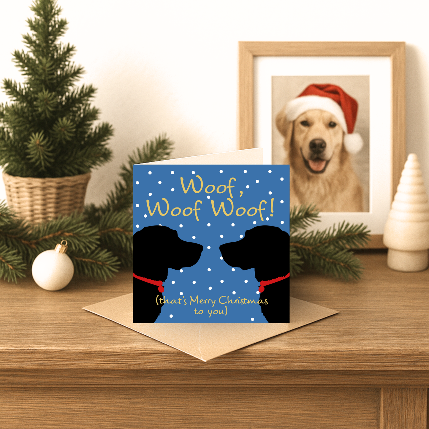 Christmas card with dog silhouettes and text on a wooden surface with festive decorations.