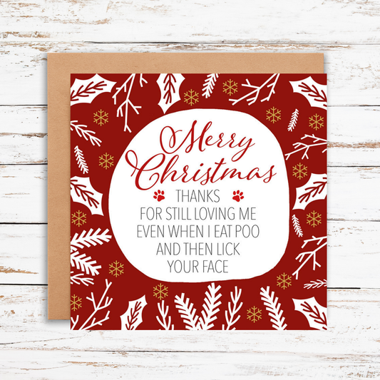Christmas card with red and white design on a wooden surface