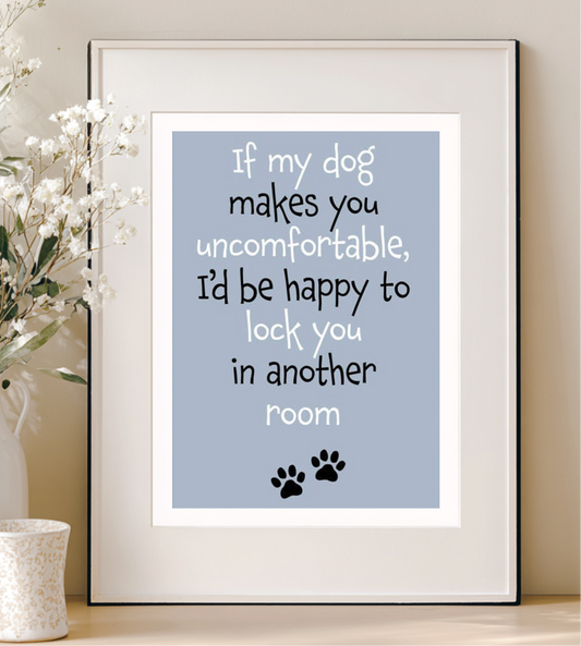 Framed print with humorous text about a dog on a light blue background, displayed on a shelf.