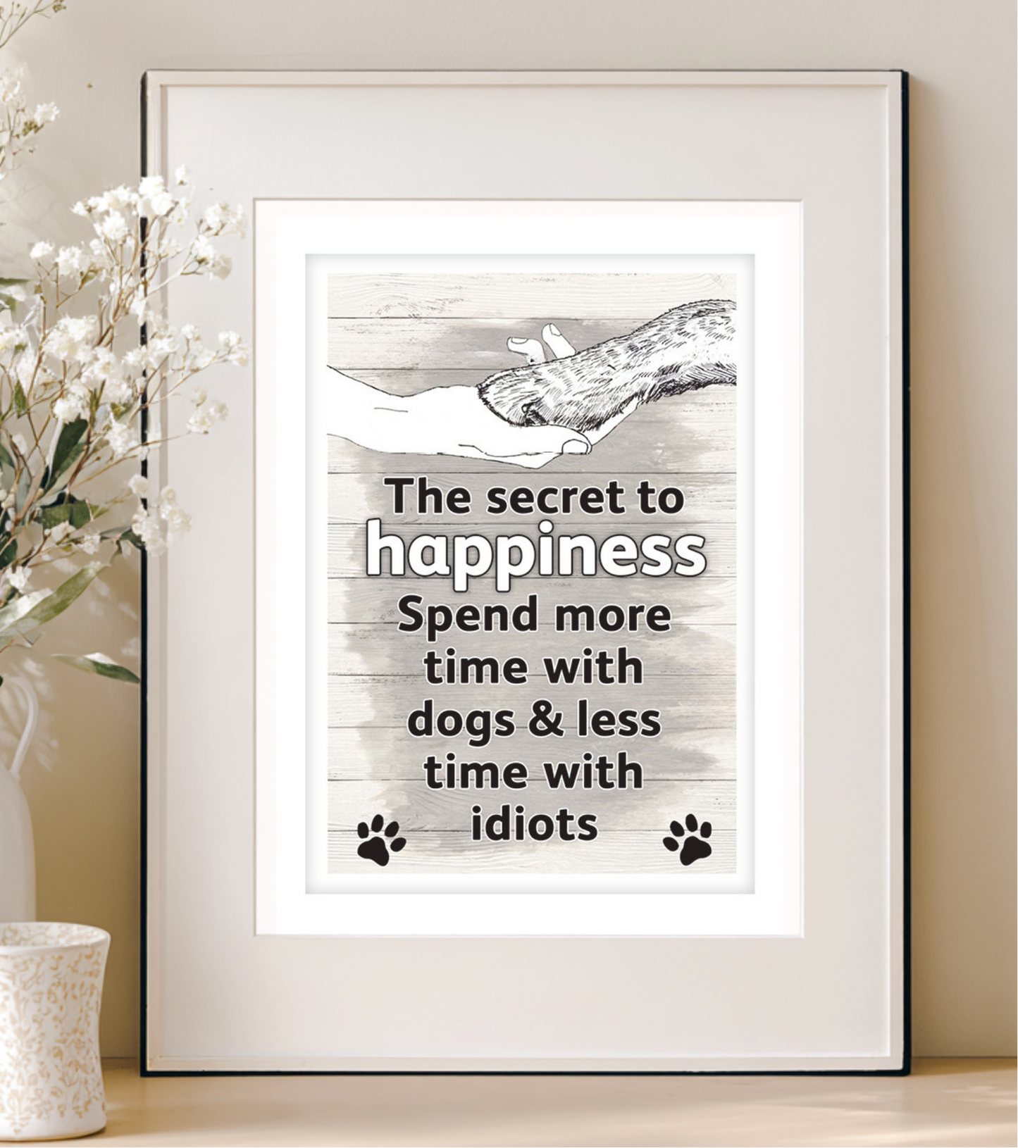 Framed print with a humorous quote about dogs on a wall.